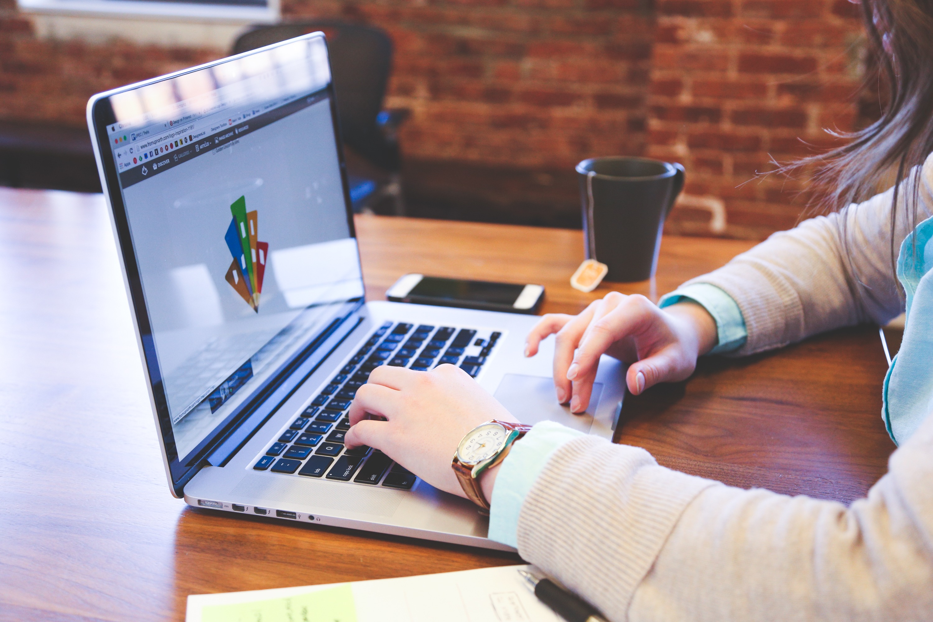 A person typing on a laptop at a table. (Proven PR strategies for startup success)