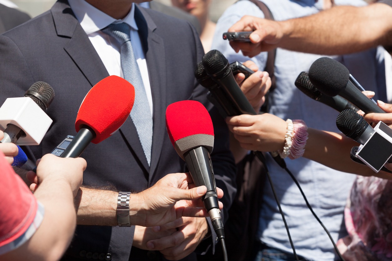 Multiple microphones in a person's face during a media interview. (Saying ‘no’ to your CEO is vital to media training)