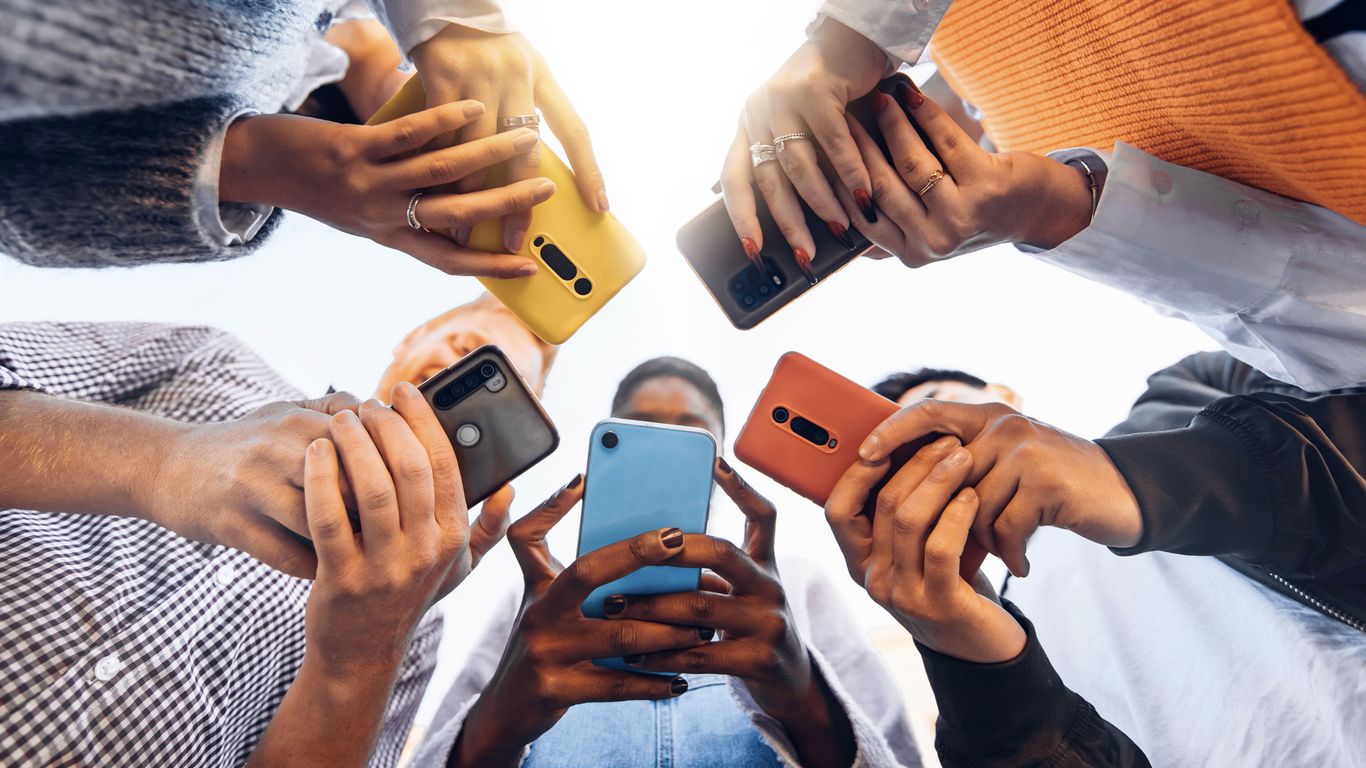 people gather in a circle while using their phones