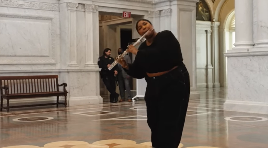Lizzo shown playing the flute at the Library of Congress