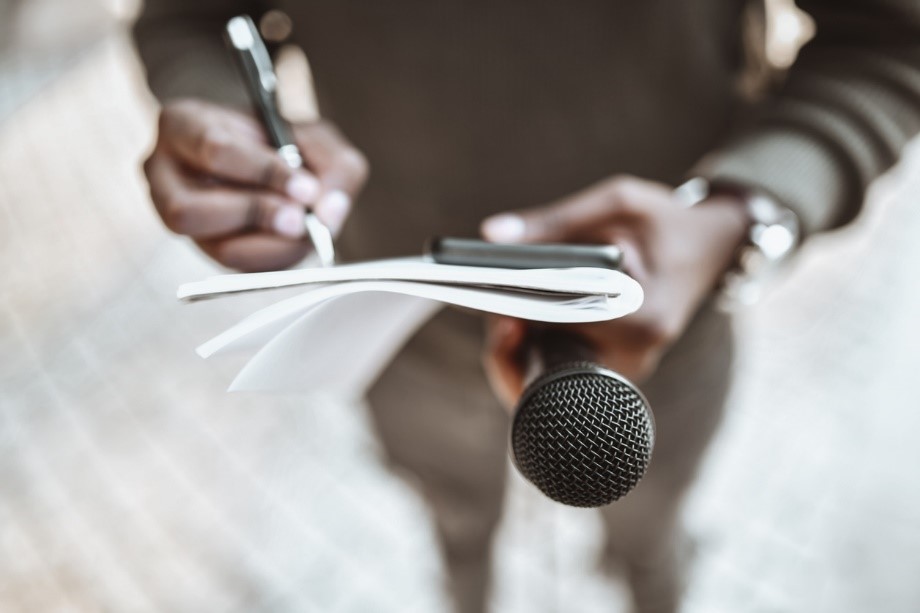 reporter taking notes during a press conference