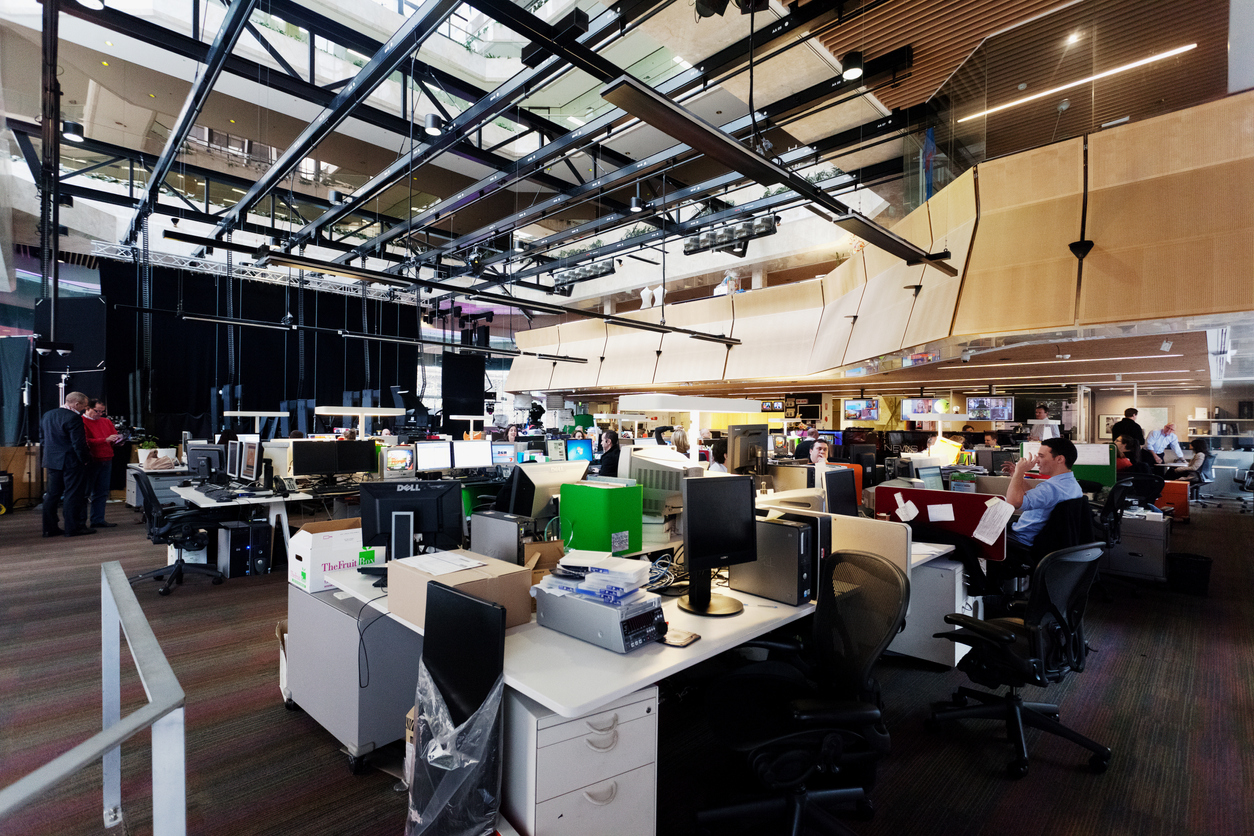 A newsroom with mostly empty desks shows the shrinking media industry.