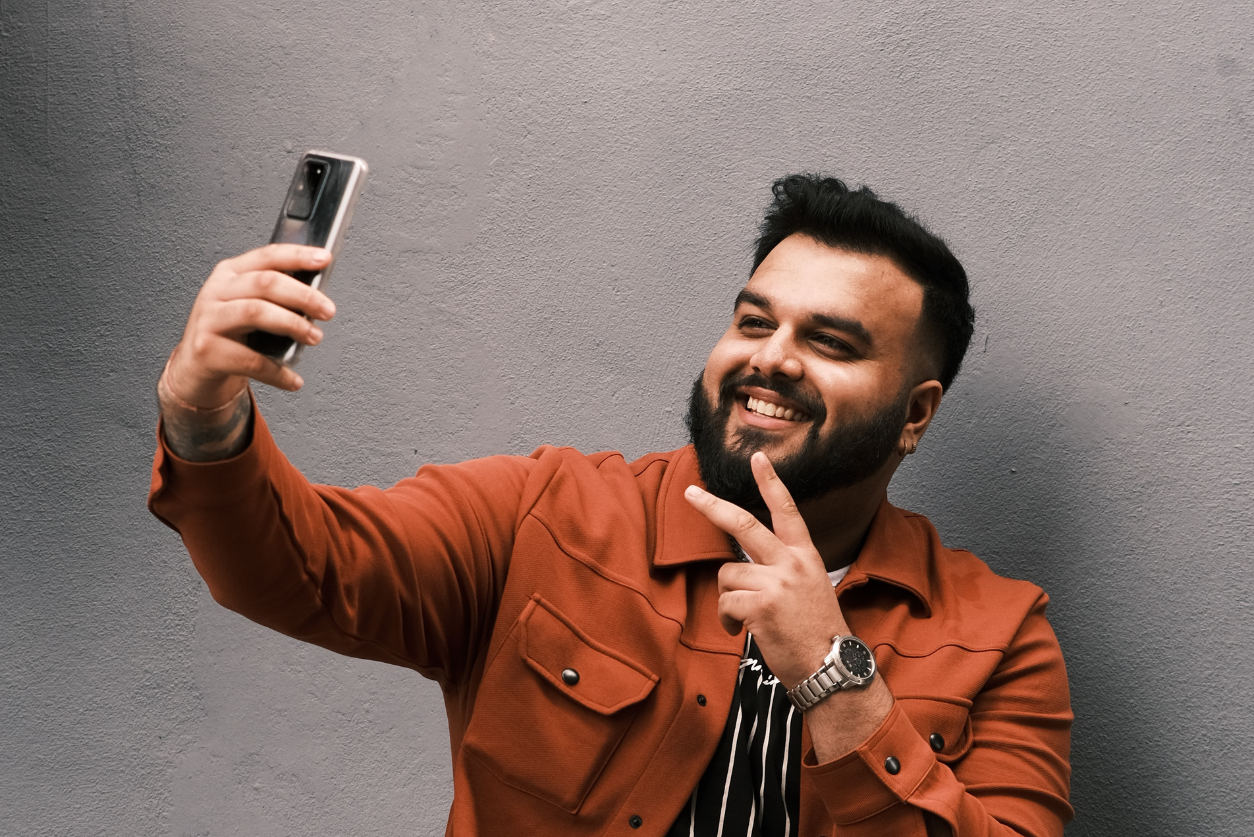 An image showing a man taking a selfie with his phone accompanying an article about brand creator partnerships.