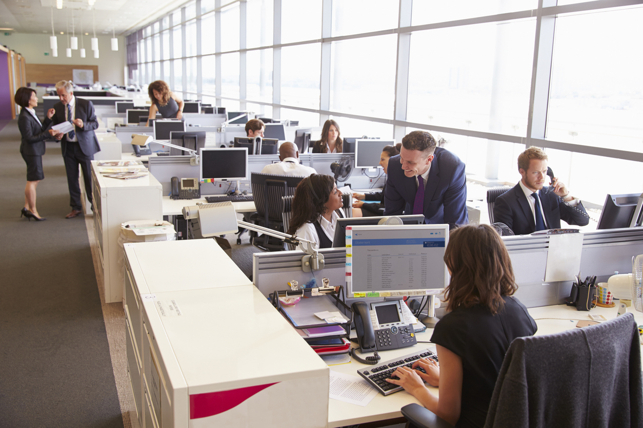 Manager in discussion with coworker in an open plan office